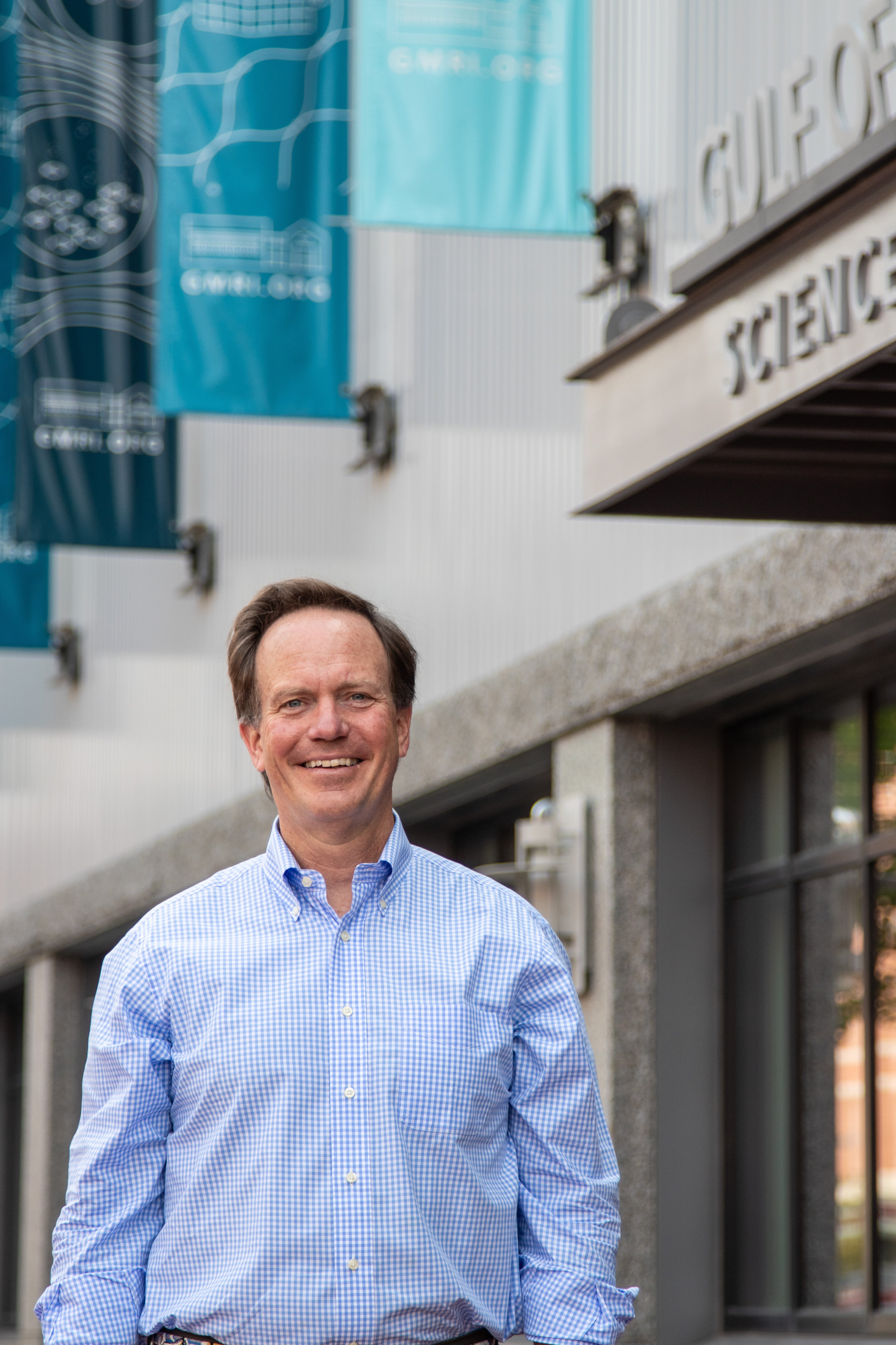 Man smiling in front of building