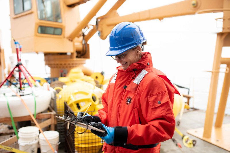 New GMRI Chief Scientific Officer Janet Duffy-Anderson taking notes aboard a research vessel.