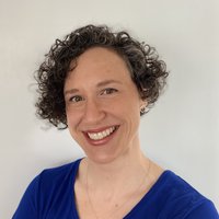 A portrait of a woman smiling in a blue shirt,