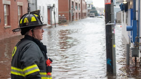 A fireman looks over a flooded wharf.