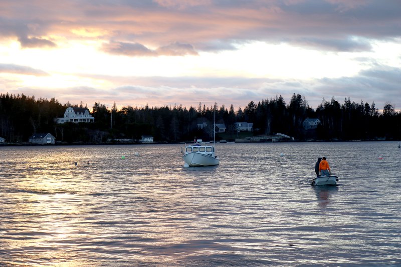 A sun sets over a working waterfront.