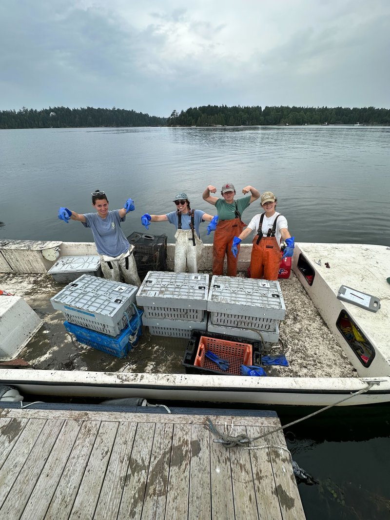 A group of interns stand on a boat.