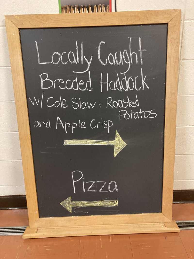 This is a blackboard with chalk writing on it announcing the school lunch.