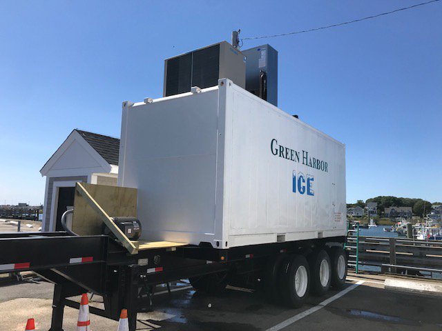 A large ice machine sits on a pier.