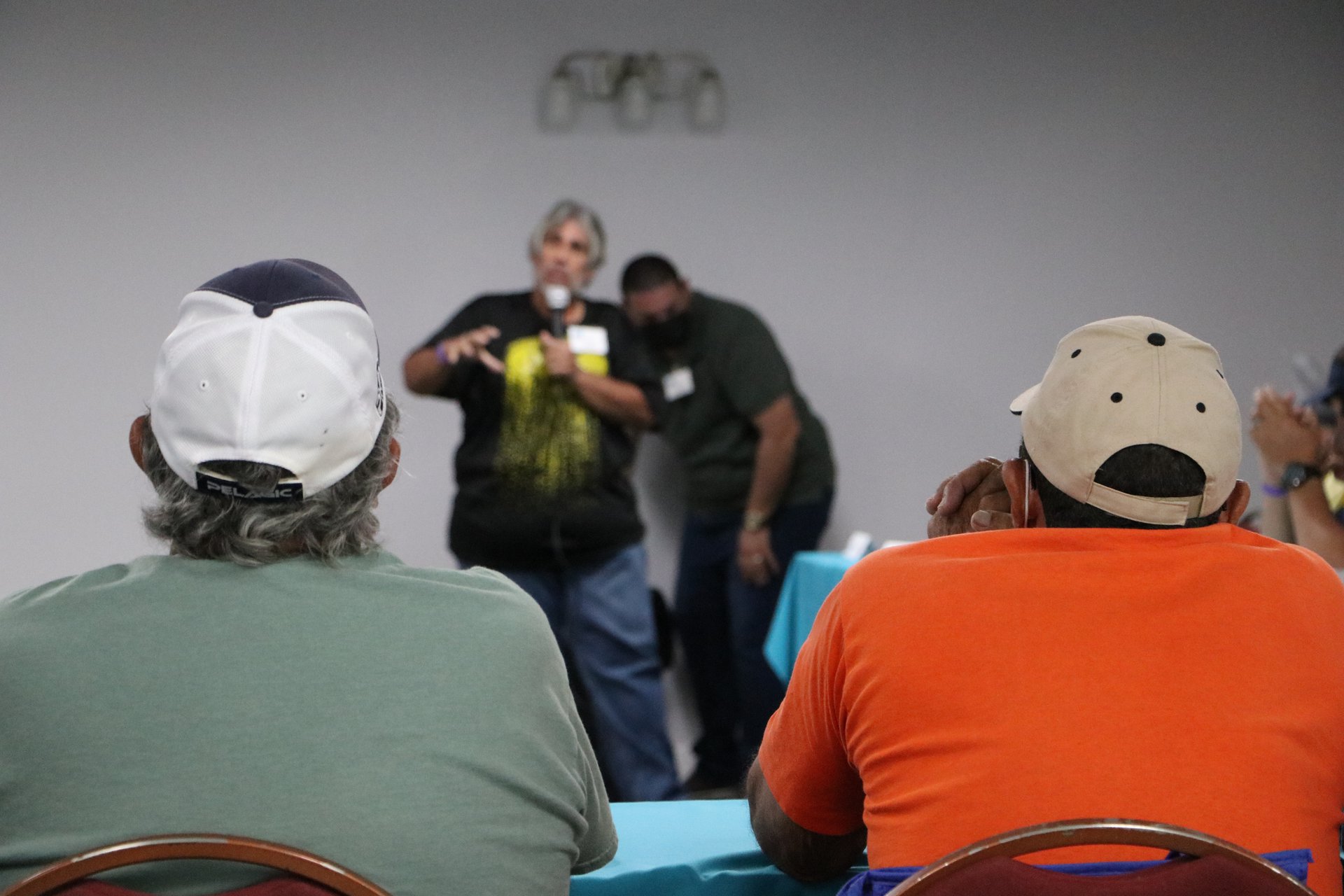 Two men watch another give a presentation.