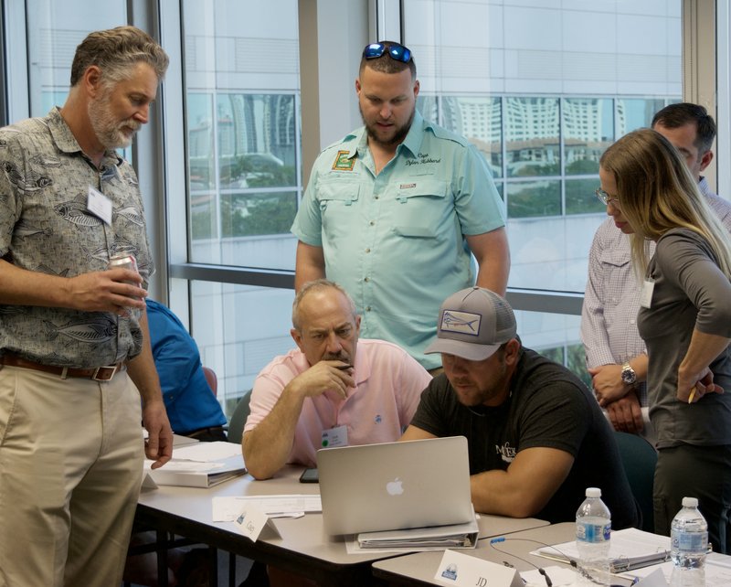 Members of the Southeast MREP workshop gathered around a computer.