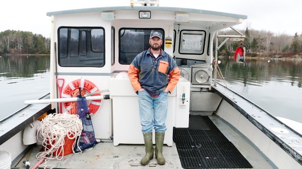 Lobsterman looking at the camera on board a lobster boat