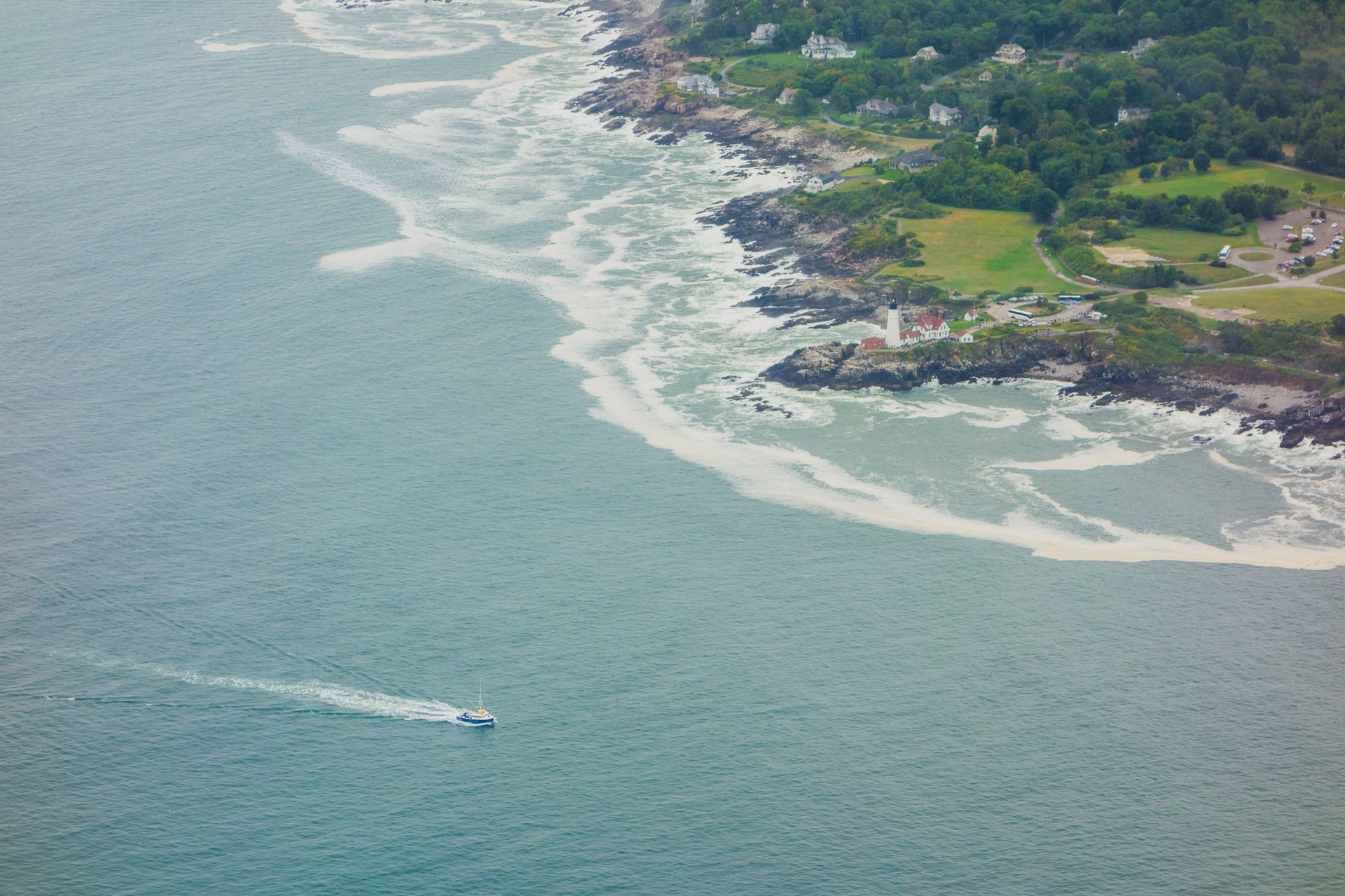 This is an aerial shot of a coastline with a boat.
