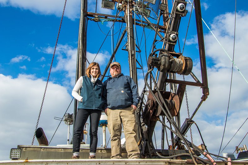 Fisheries Technical Assistance Program Manager Heather Cronin stands aboard a ship with recently mounted electronic monitoring cameras alongside a fisherman.