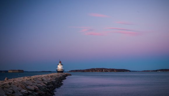 Lighthouse at the end of a breakwater at dusk