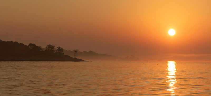 A hot sun over the water.
