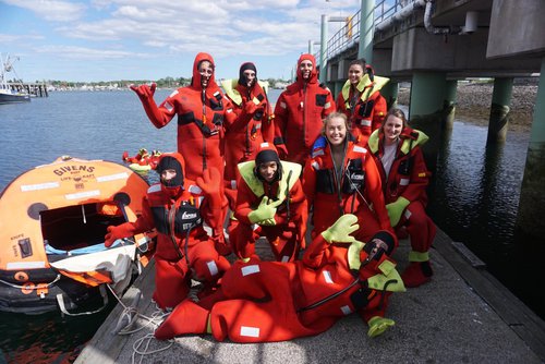 REU students in red diving gear pose for a photo.