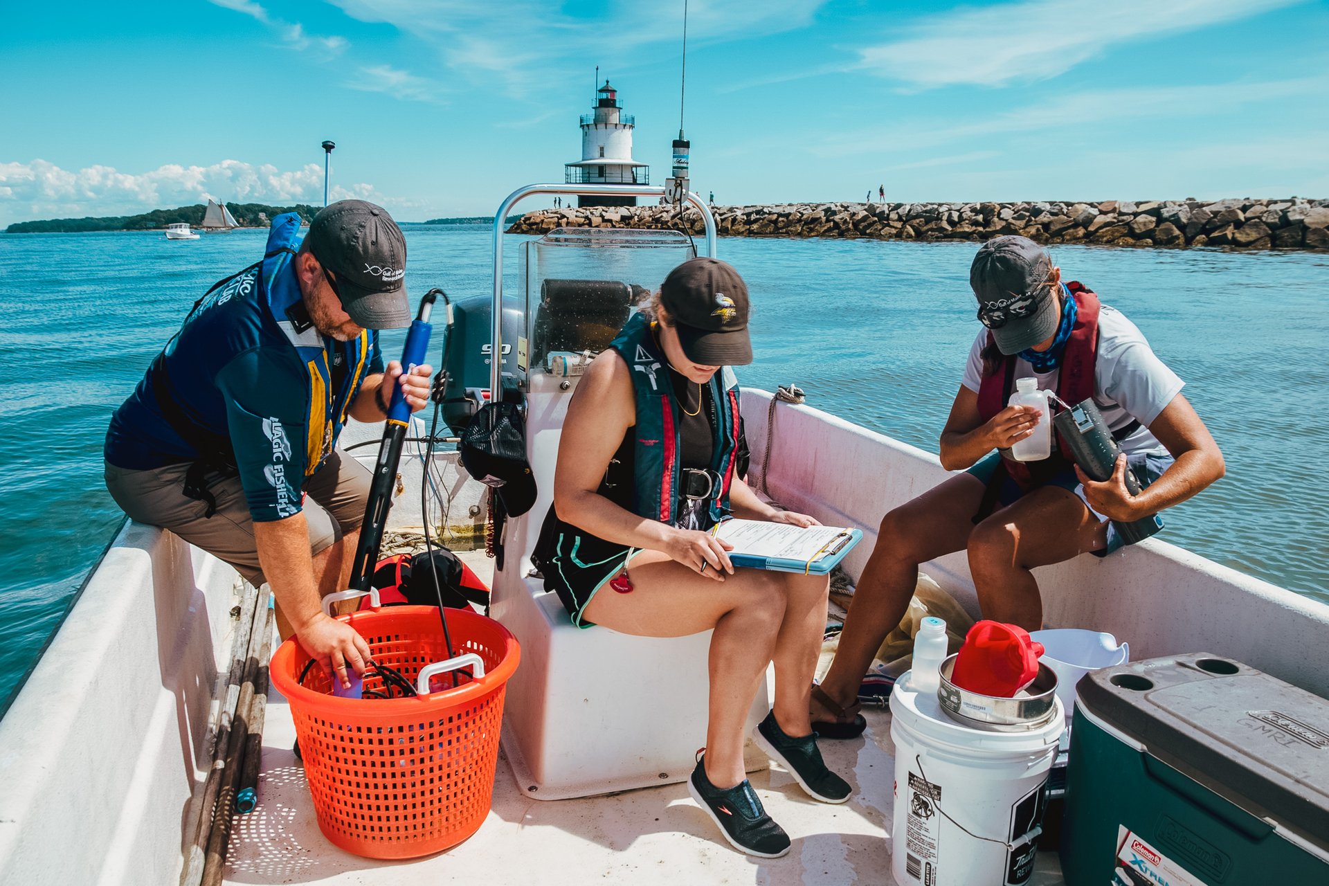 three field techs aboard the skiff on the ocean