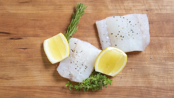 raw redfish on a cutting board with herbs