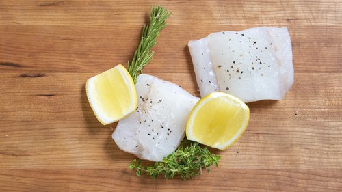 raw redfish on a cutting board with herbs